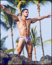 Right side view of a sexy male model wearing bang one swim mini briefs from the bang clothes company in miami.