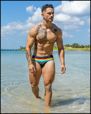 Male model at the beach wearing the FOUREVER STRIPES VOL 1 men's bikini-style bottoms by the Bang! Clothes brand of men's swimwear from Miami.