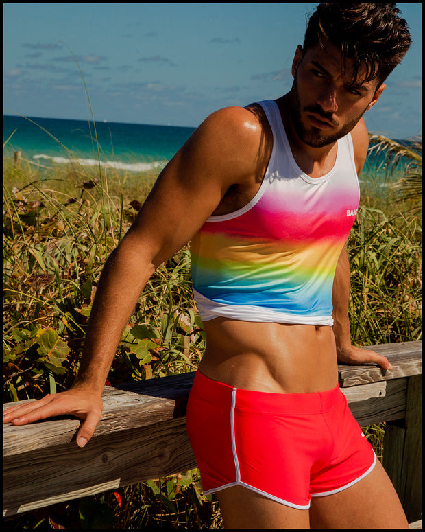 Male model outdoors wearing the HIGH VOLTAGE Swimming Shorts men’s swimsuit nad the GIMME YOUR LOVE Tank Top by BANG! Clothes the official brand of beachwear based in Miami, FL.