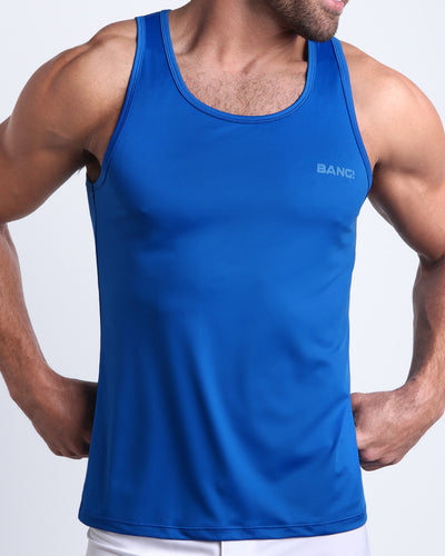 Frontal view of male model wearing the ASTRAL BLUE beach tank top for men by the Bang! brand of men's beachwear from Miami.