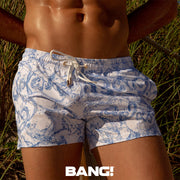 Front view of model wearing the SPLASH men’s beach shorts with water strokes in blue and white by the Bang! Clothes brand of men's beachwear from Miami.