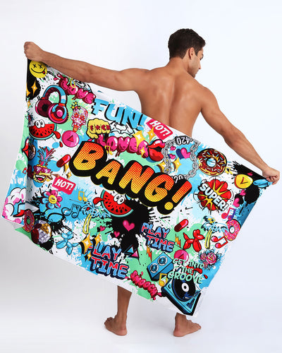 Frontal view of sexy male model showing the BANG ONE unisex lightweight towel featuring fun and energetic comics-style graphics in bold colors, with a prominent BANG! illustration.