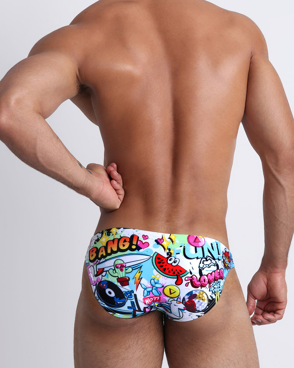 Back view of model wearing a swim mini-brief in a vibrant fun classic Bang! Miami print. 