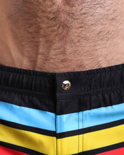 Close-up view of the BIONIC STRIPES men’s beach shorts, showing custom branded metal button in gold by Bang!