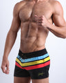 Side view of the Bionic Stripes swim trunks for men in dark black with stripes in red, yellow and blue by Bang! Clothing of Miami.