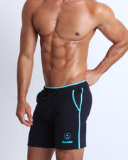Frontal view of male model wearing the athletic crossfit gym shorts in a solid black color by the Bang! brand of men's beachwear from Miami.