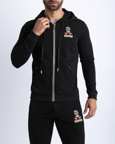 Frontal view of male model wearing the BANG! Clothes BLACK Tracksuit Hoodie Jacket with frontal zipper closure. This long-sleeve jacket has an embroidered Bang! Logo with the signature Mister TJ tiger. 