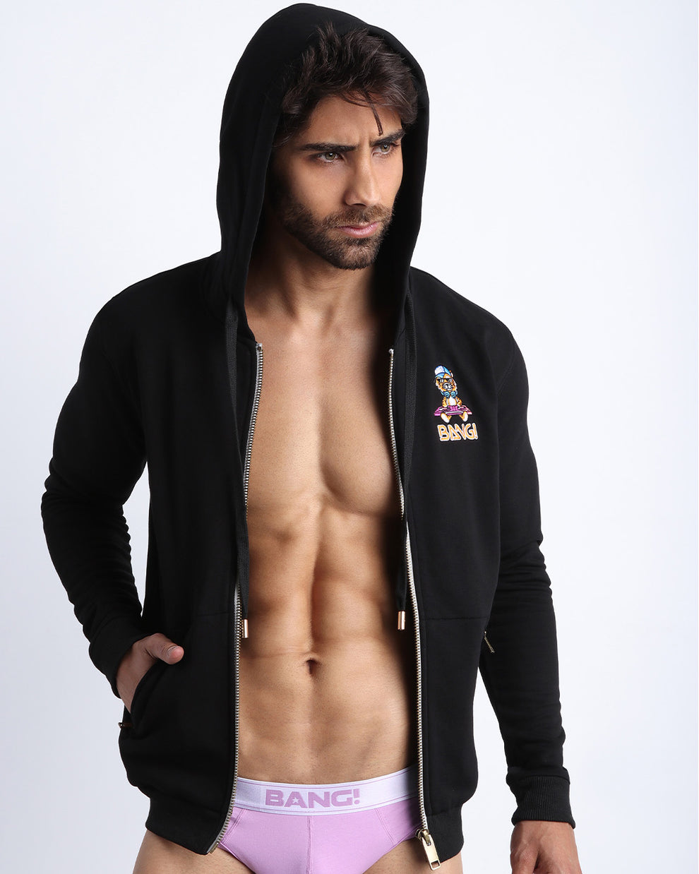 Sexy male model wearing the perfect BLACK men's zippered hoodie to keep you warm during chilly fall weather. With it's soft, warm fabric and it's two front pockets and hood with adjustable drawcord. 