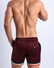 Back view of a model wearing woven twill cotton chino shorts in fire burgundy color for men by BANG! Clothing brand of Miami.
