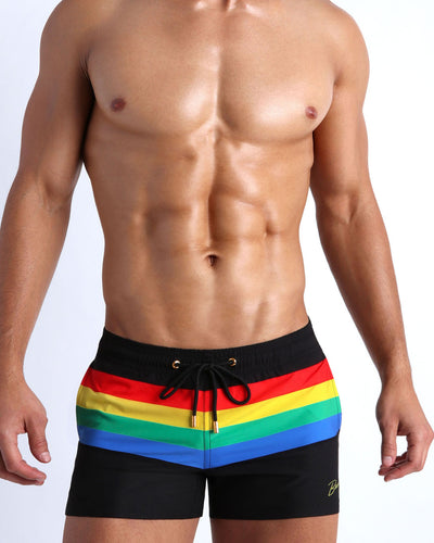 Male model wearing the FOUREVER STRIPES VOL 1 men's beach shorts by the Bang! Clothes brand of men's swimwear from Miami.