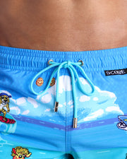 Close-up view of inseam and details of 8-BIT WILD BEACH PARTY swimsuit for men, with blue cord and custom branded golden cord-ends, and matching custom eyelet trims in gold.