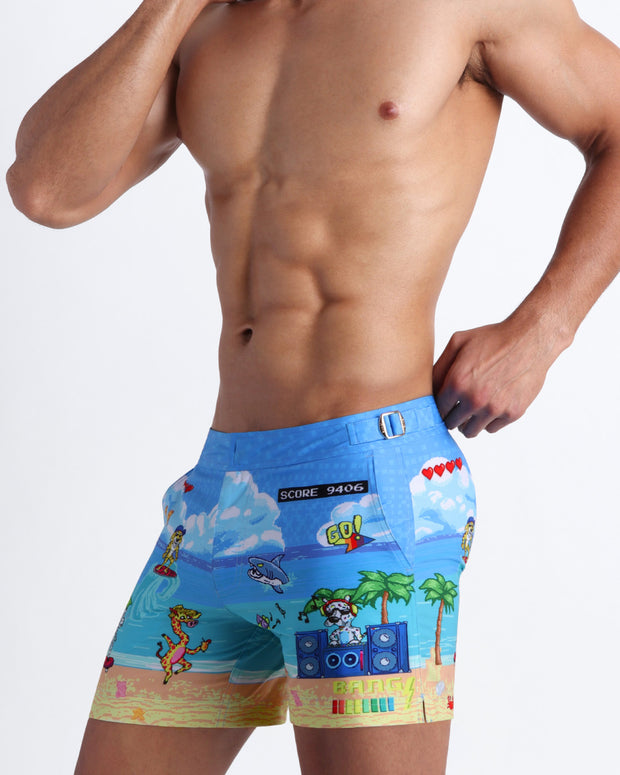 Side view of a man wearing the 8-BIT WILD BEACH PARTY swim trunks by Bang! Clothes with 80s Sega video game graphics.