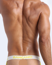 Back view of model wearing the BANGNANARAMA YELLOW Men’s beathable cotton Jockstrap for men by BANG! Offers light compression for perfect contouring to the body and second-skin fit.