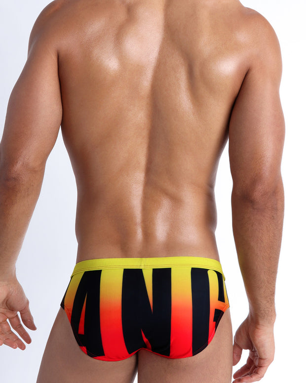 Back view of a model wearing BIG BANG GOLDEN HOUR men’s beach briefs made by the Bang! Miami official brand of men&