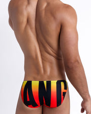 Back view of a model wearing BIG BANG GOLDEN HOUR men’s beach mini-briefs made by the Bang! Miami official brand of men's swimwear.