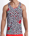 Frontal view of model wearing the SO RED THE ROSE men’s beach coton tank top with leopard print in white and black tones with red roses by the Bang! menswear brand.