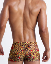 Male model's back view showing the CATS N'ROSES beach trunks for men featuring animal print of brown cheetah with red roses by Bang! Miami.