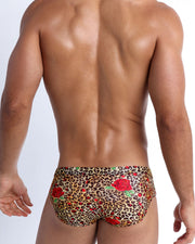 Male model's back view showing the CATS N'ROSES beach briefs for men featuring animal print of brown cheetah with red roses by Bang! Miami.