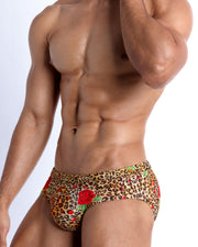 Lateral view of a man wearing the CATS N'ROSES Summer men swimsuit by Bang! Clothes in brown leopard animal print with red roses.