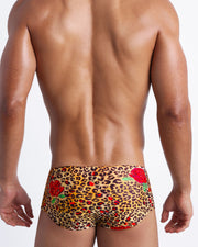 Male model's back view showing the CATS N'ROSES beach sungas for men featuring animal print of brown cheetah with red roses by Bang! Miami.
