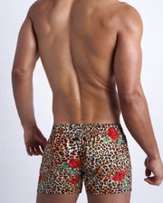 Male model's back view showing the CATS N'ROSES swim flex shorts for men featuring animal print of brown cheetah with red roses by Bang! men's swimwear.