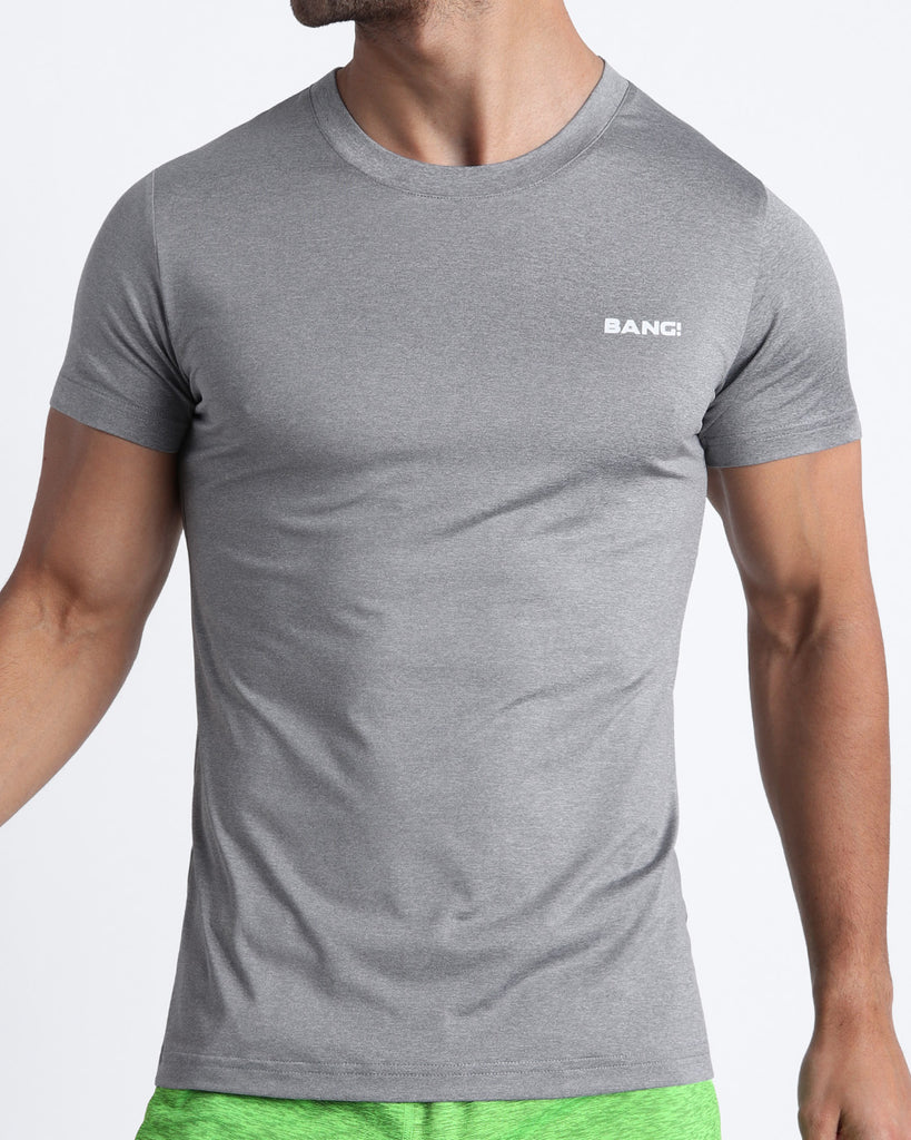 Frontal view of male model wearing the COMPOUND GREY in a solid grey quick-dry workout shirt by the Bang! brand of men's beachwear from Miami.