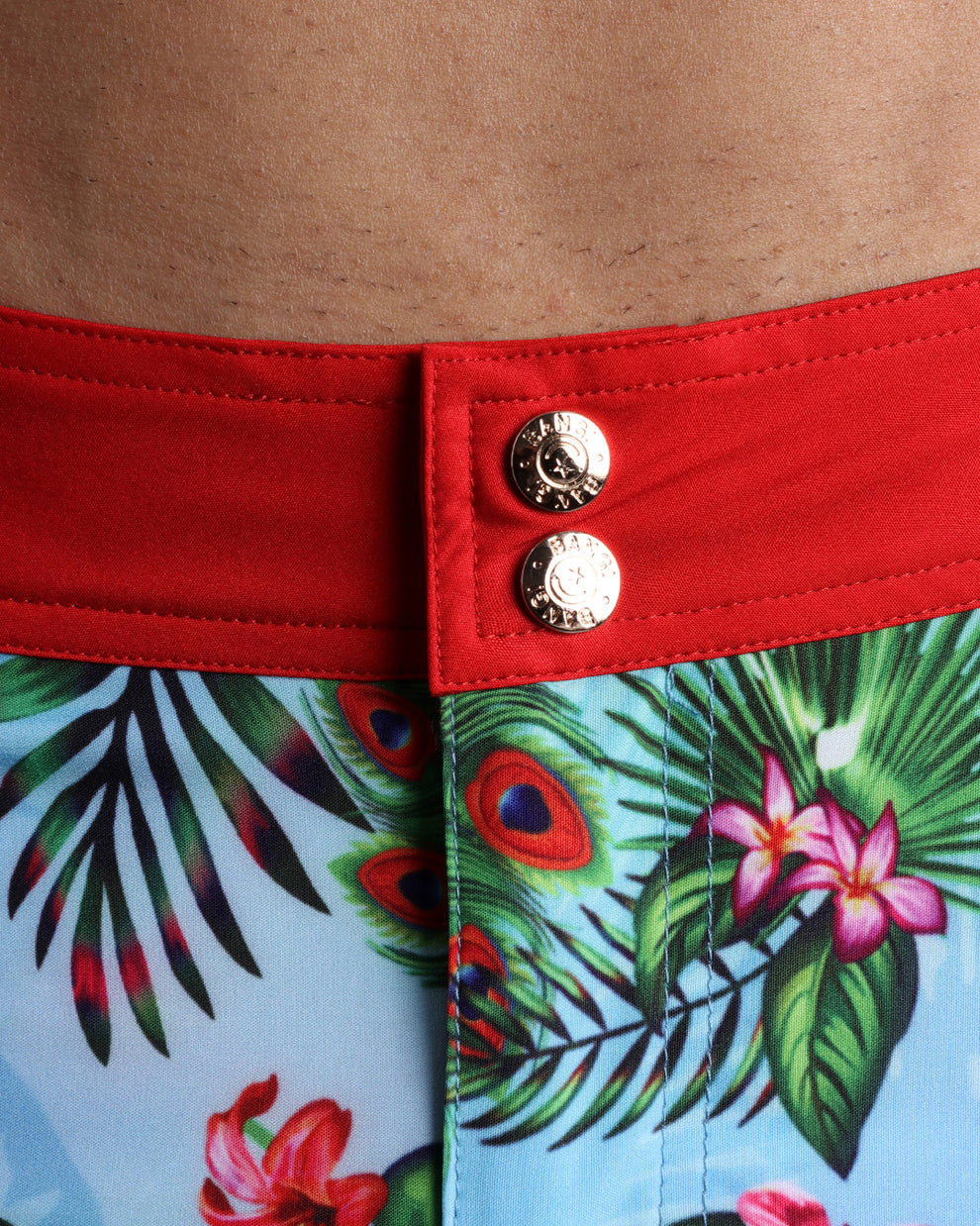 Close-up view of men’s summer beach shorts by BANG! clothing brand, showing custom branded golden buttons.
