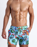 Front view of a sexy man wearing the DISCO JUNGLE swim shorts featuring a fun and energetic jungle graphics in bold colors, with a tiger illustration.