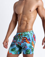 Side view of a men's torso showing the DISCO JUNGLE swim trunks for men in colorful jungle graphic by the Bang! brand of menswear from Miami.