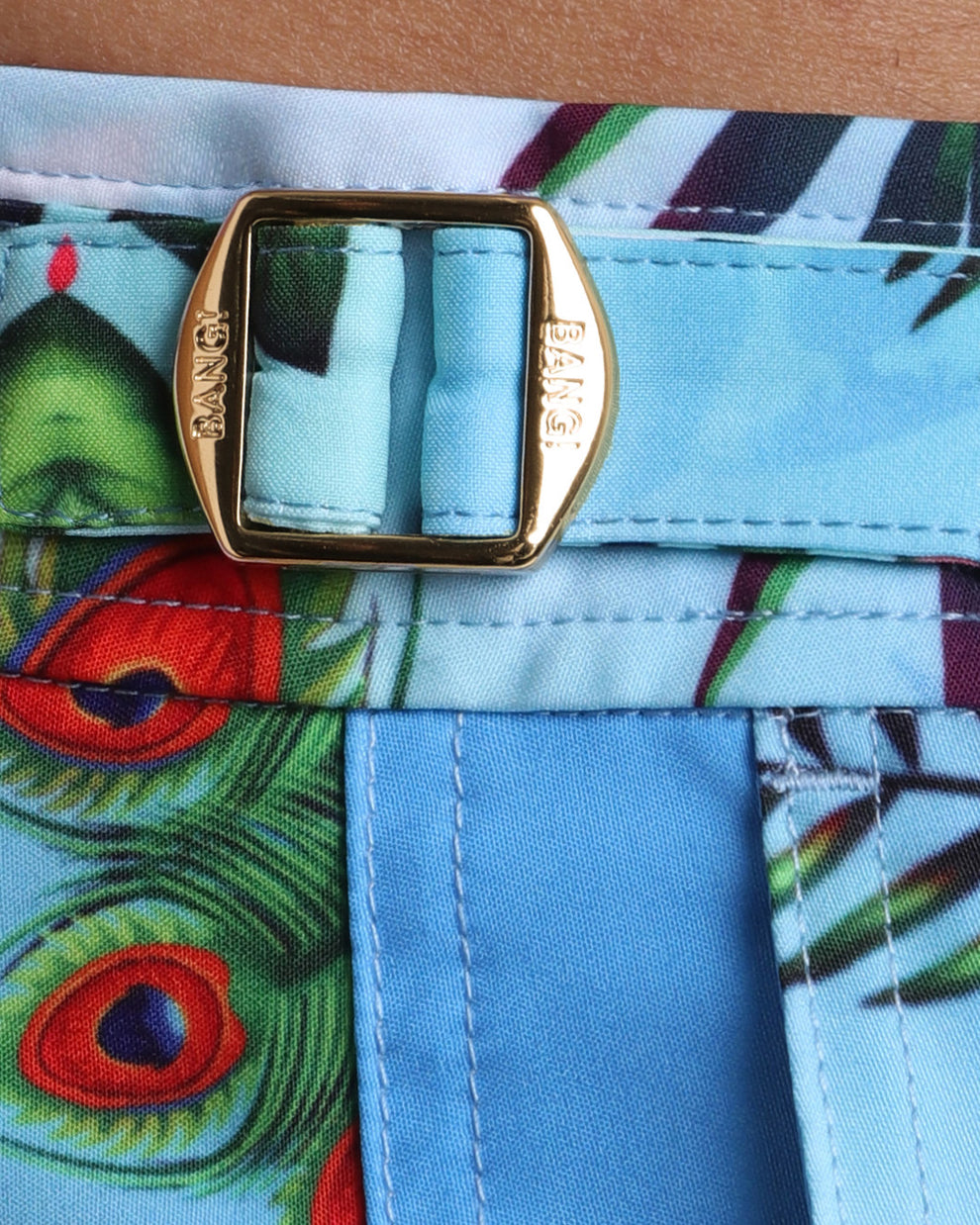 Close-up view of the DISCO JUNGLE men’s tailored shorts, showing custom branded golden adjustable side buckles.