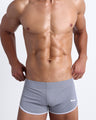 Frontal view of a sexy male model wearing men’s swimsuit in gray color by the Bang! Menswear brand from Miami.