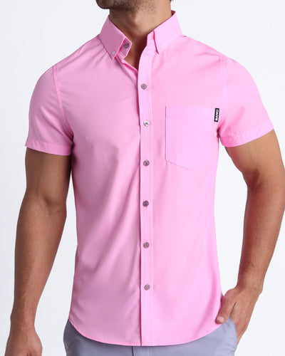 Front view of a sexy male model wearing LA BEACH EN ROSE mens short-sleeve stretch shirt in light pink by the Bang! brand of men's beachwear from Miami.