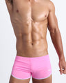 Frontal view of a sexy male model wearing men’s swimsuit in light pink by the Bang! Menswear brand from Miami.