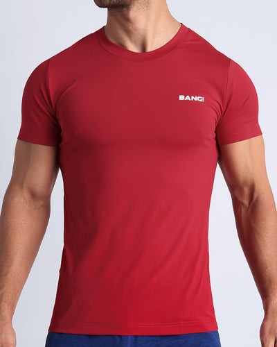 Frontal view of male model wearing the MAJESTIC RED in a solid bright red quick-dry workout shirt by the Bang! brand of men's beachwear from Miami.