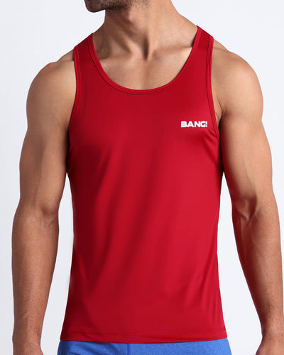 Frontal view of male model wearing the MAJESTIC RED in a solid workout tank top for men's by the Bang! brand of men's beachwear from Miami.