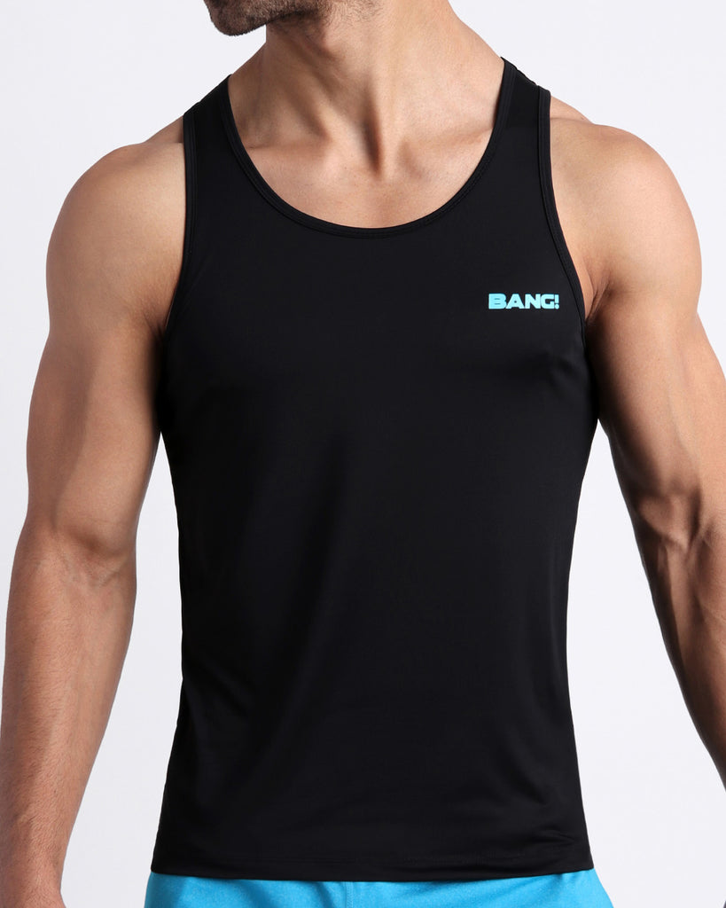 Frontal view of male model wearing the NEUTRON BLACK in a black men's fitness tank top tank top by the Bang! brand of men's beachwear from Miami.