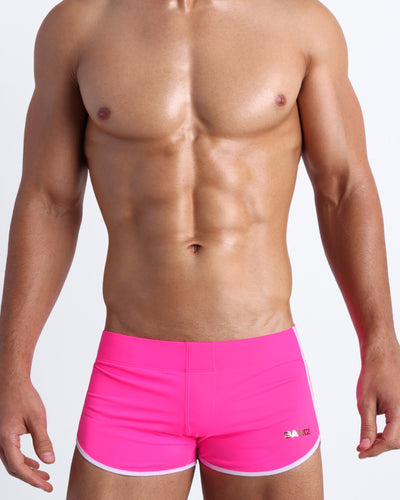 Frontal view of a sexy male model wearing men’s swimsuit in hot pink color by the Bang! Menswear brand from Miami.