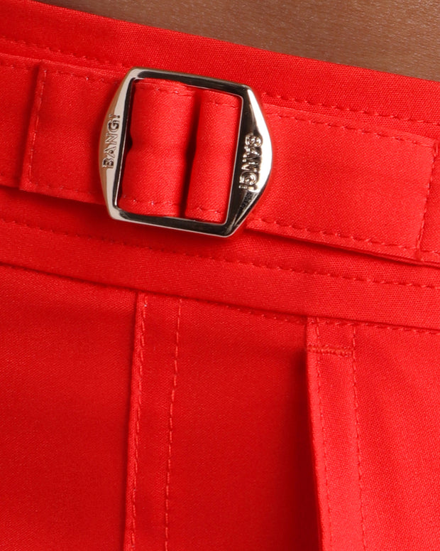 Close-up view of the PRIME RED men’s swimwear, showing custom branded golden adjustable side buckles.