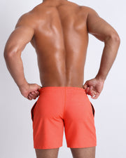 Back view of the PUMPED ORANGE men's fitness sweatshorts in a burnt orange color by BANG! menswear Miami.