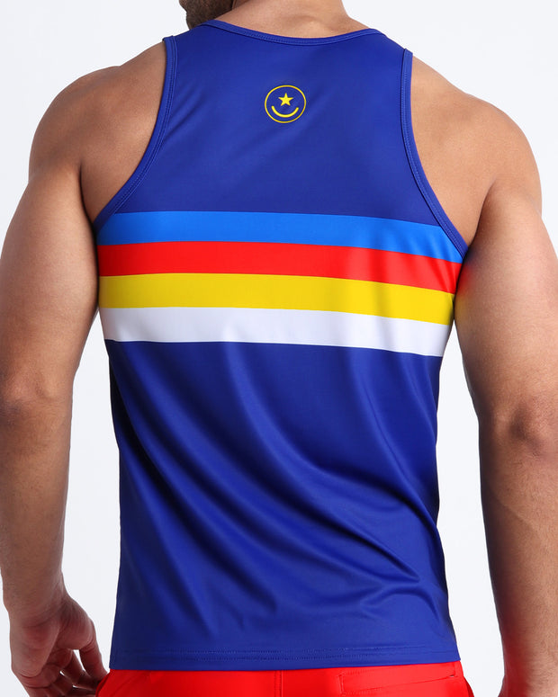 Back view of male model wearing a tank top for men in blue color with color stripes in white, bold red, yellow and blue.