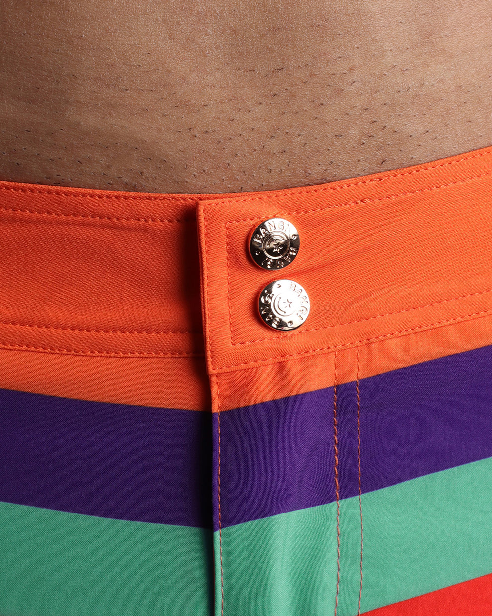 Close-up view of men’s summer beach shorts by BANG! clothing brand, showing custom branded golden buttons.