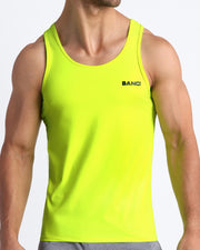 Frontal view of male model wearing the ULTRA NEON in a solid bright lime green gym tank top for men by the Bang! brand of men's beachwear from Miami.