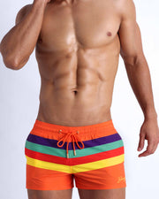 Male model wearing the Stripe'A'Pose REMIX men's beach shorts by the Bang! Clothes brand of men's swimwear from Miami.