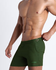 Side view of ALPHA GREEN men’s swimsuit shorts in army green made by Miami-based Bang Clothing of men's beachwear
