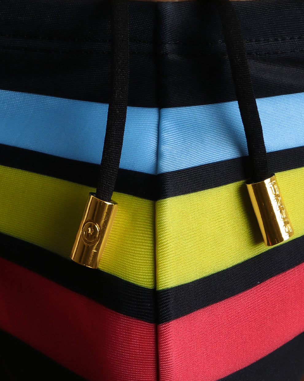 Close-up view of the Bionic Stripes men’s swim mini brie, showing black cord with custom branded golden cord-ends, and matching custom eyelet trims in gold by Bang! Miami.