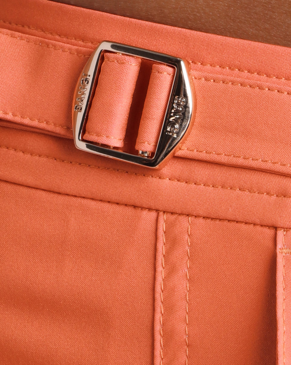 Close-up view of the BRONZE FACTOR men’s swimwear, showing custom branded golden adjustable side buckles.