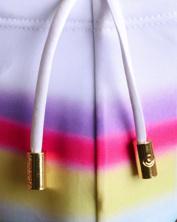 Close-up view of men’s summer swim mini brief with a rainbow, showing white cord with custom branded golden cord ends, and matching custom eyelet trims in gold.