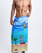 Frontal view of sexy male model showing the 8-BIT WILD BEACH PARTY unisex lightweight towel featuring scenes of retro 80s Nintendo video game, Atari, Sega, Commodore 64.