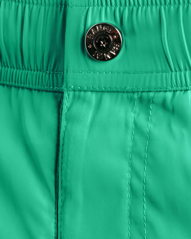 Close-up view of the AQUA GLOW men’s summer mini shorts, showing custom branded metal button in gold.