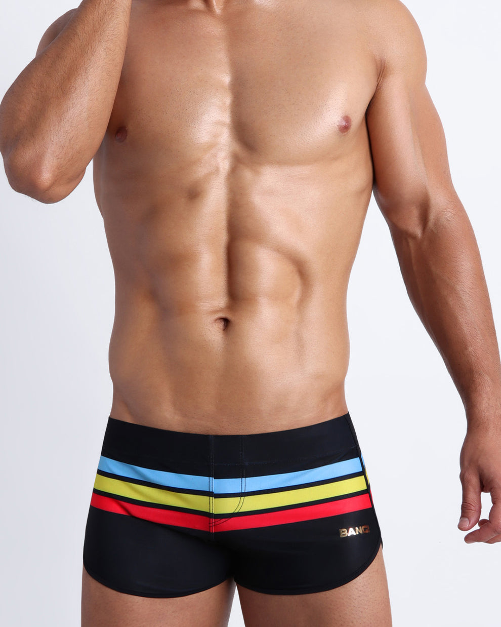 Frontal view of model wearing the BIONIC Stripes men’s swimsuit by the Bang! brand of men's beachwear from Miami.